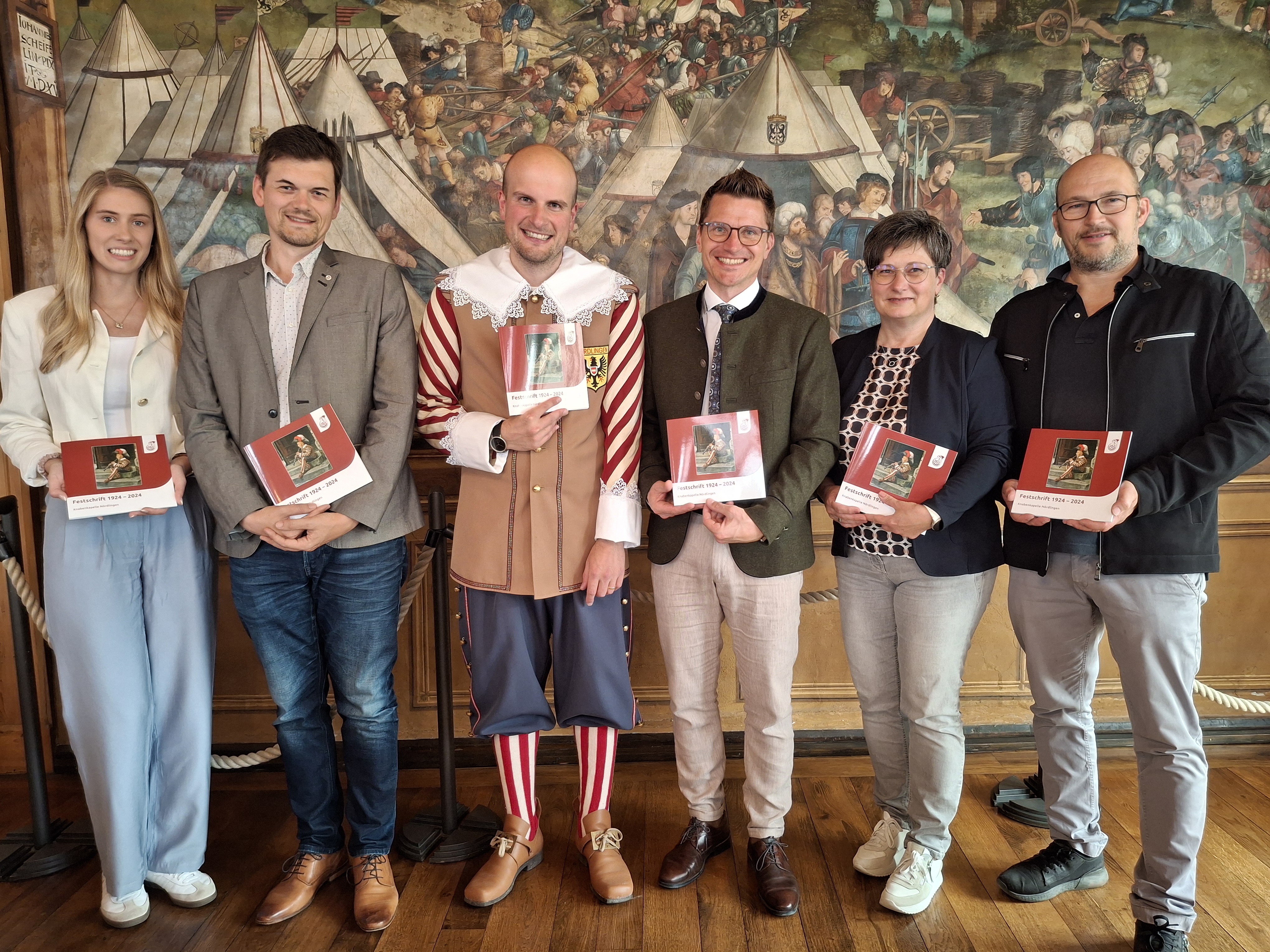 (v.l.) Hauptverwaltungsleiterin Helena Ott, Stadtarchivar Dr. Johannes Moosdiele-Hitzler, Stadtkapellmeister Oliver Körner, Oberbürgermeister David Wittner, Birgit Kapeller (Hauptverwaltung) sowie Thomas Volk (Druckerei Steinmeier) präsentieren die Festschrift zum 100-jährigen Jubiläum der Knabenkapelle Nördlingen.