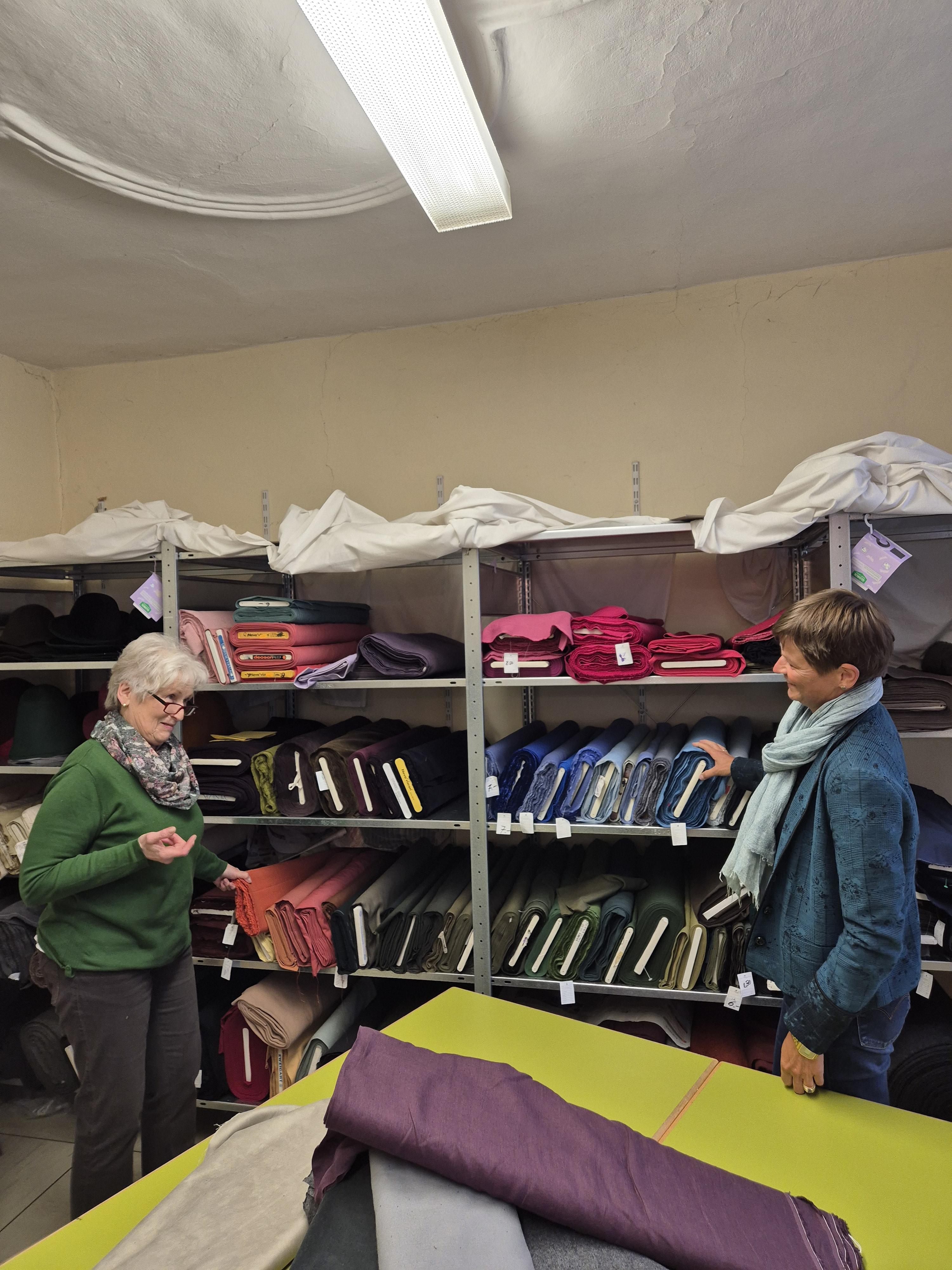 Leiterin der Nähstube, Brigitte Wirth (links), und Nähdame Susanne Schaffer (rechts) vor den Stoffen für histori-sche Gewänder im Stofflager in der ehemaligen Jugendherberge an der Kaiserwiese.