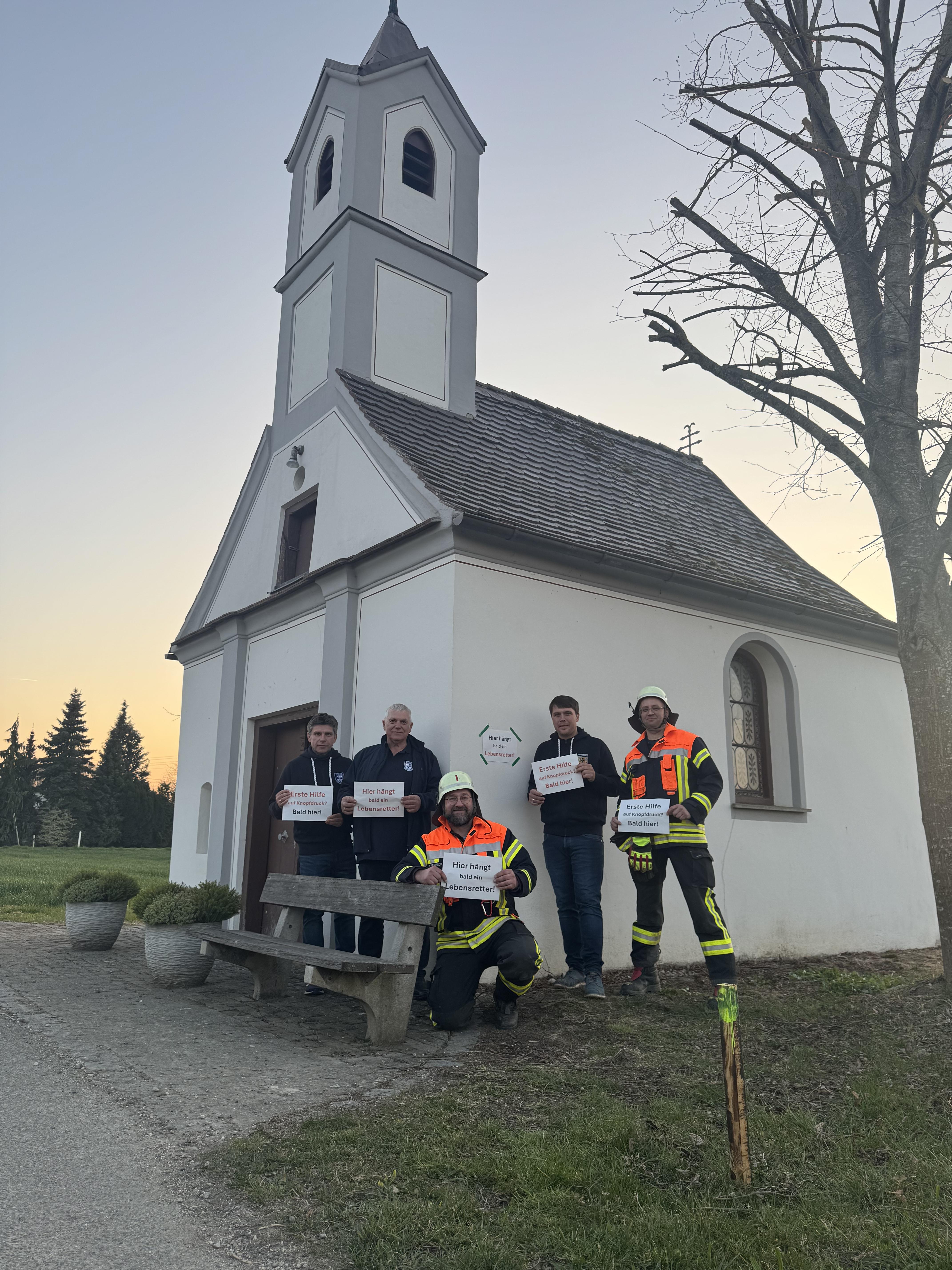Angehörige der Freiwilligen Feuerwehr Zusum-Rettingen von der Kapelle in Rettingen, wo mit finanzieller Unterstützung von Oettinger ein Defibrillator angebracht werden soll.