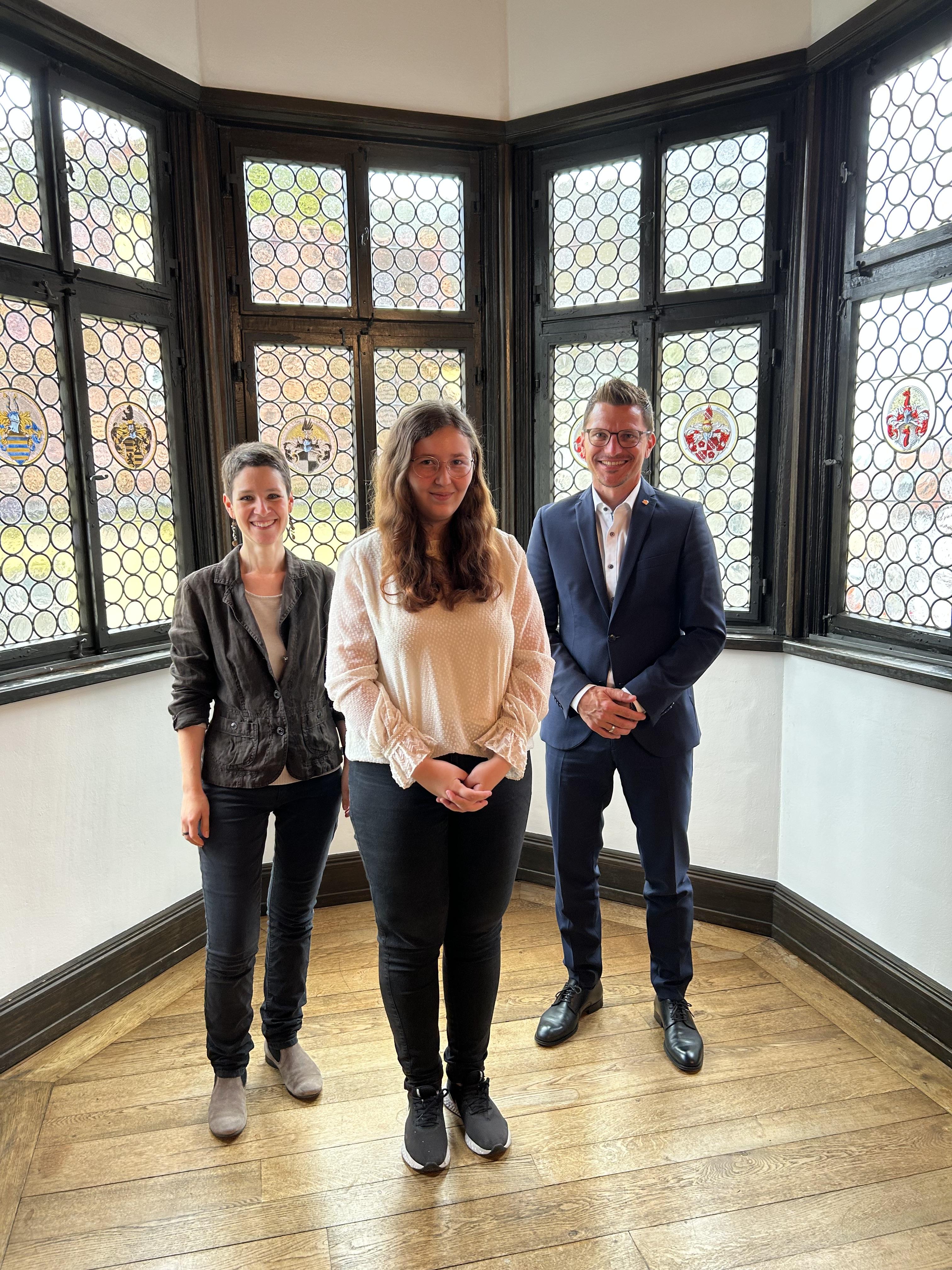 Feierlicher Moment: (v. l.) Bibliotheksleiterin Kathrin Häffner, Absolventin Emilia Götz und Oberbürgermeister David Wittner bei der Übergabe des Abschlusszeugnisses.