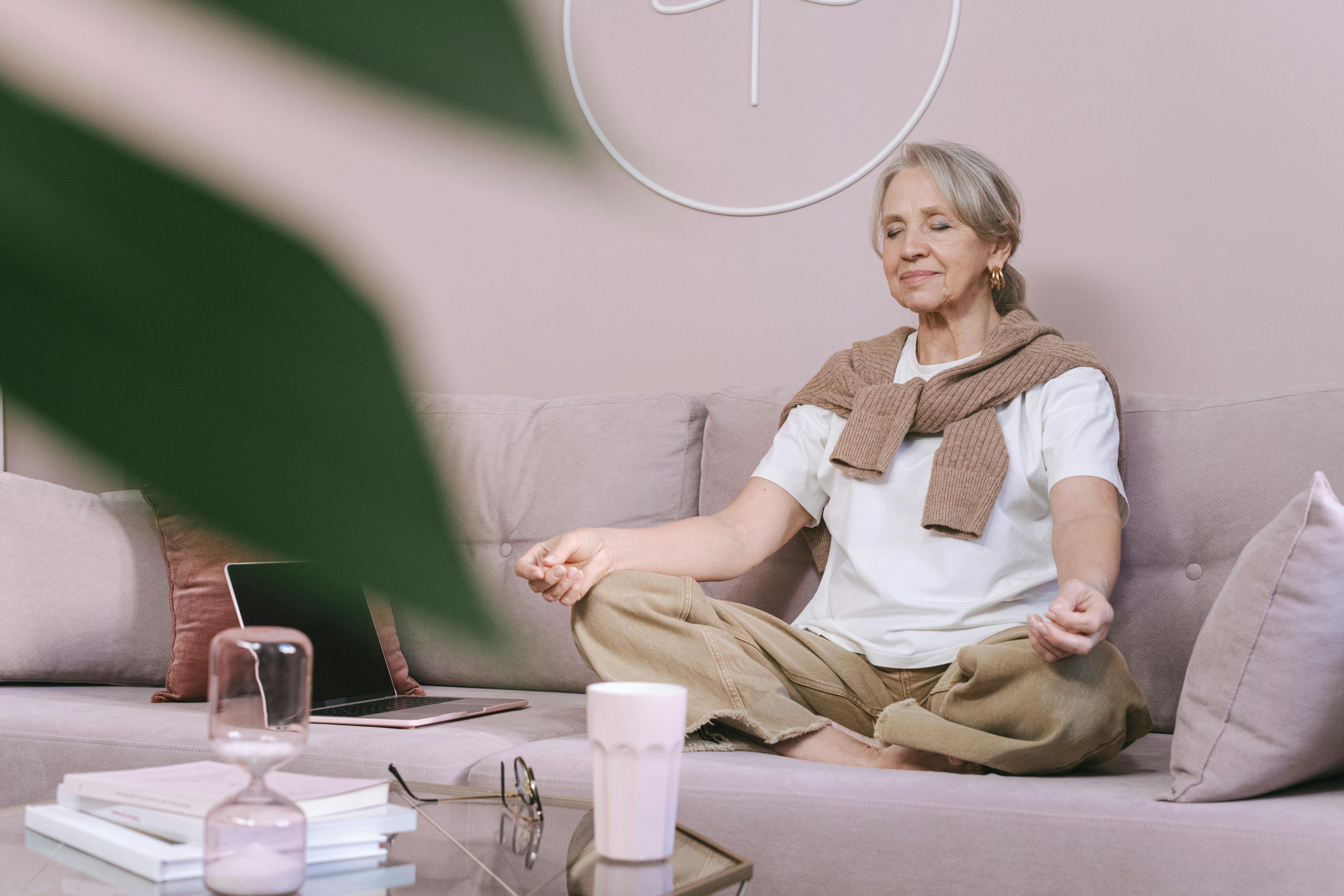 Frau meditiert auf dem Sofa